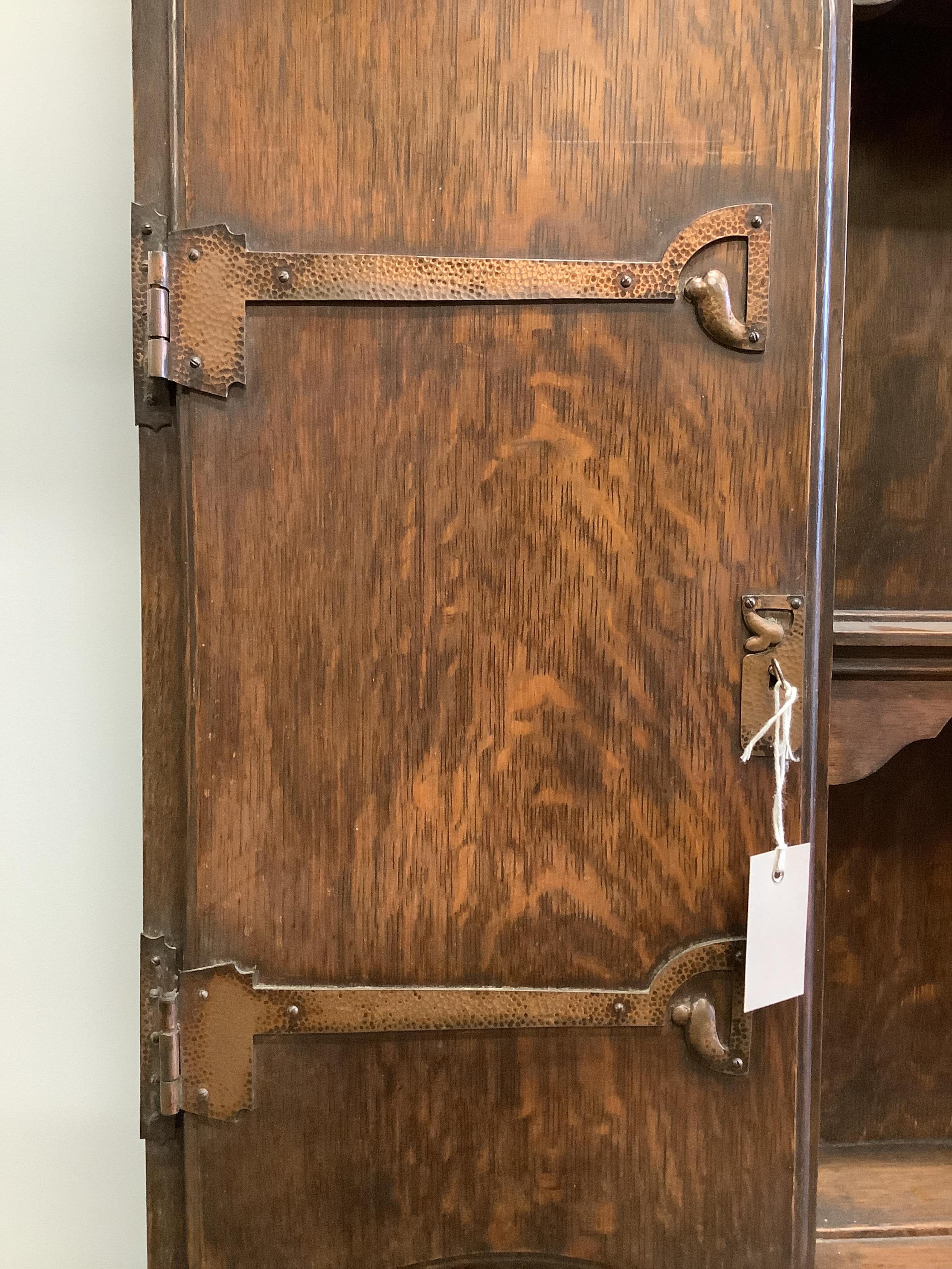 An early 20th century Liberty style oak dresser, width 157cm, height 208cm. Condition - damage to the top left of the cornice otherwise looks to be in good order